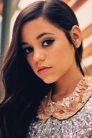 Close-up beauty portrait with smoky eye makeup and floral collar detail in warm striped light
